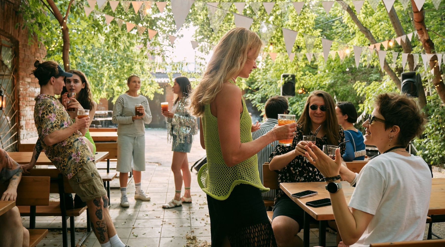 a group of people hanging out on a patio with trees covering it